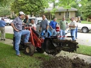 Irrigation specilist with a trencher on a lawn in Carrollton, TX